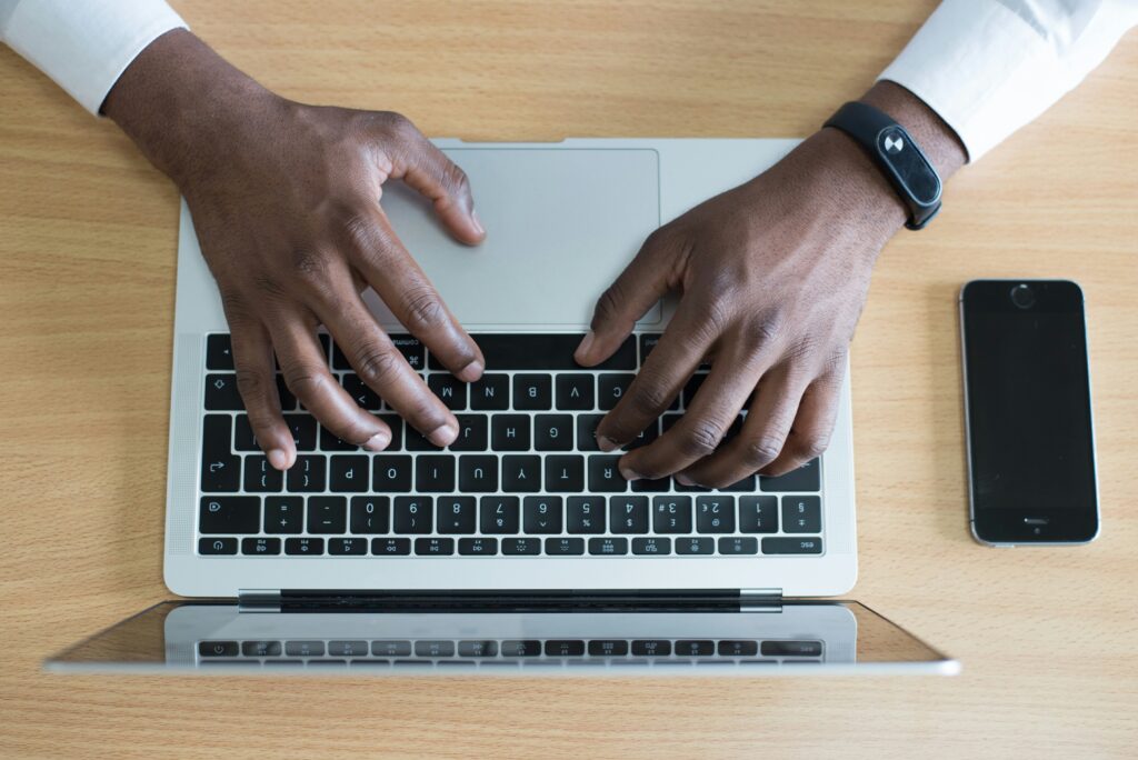 person's hand on MacBook near iPhone flat lay photography person's hand on MacBook near iPhone flat lay photography
